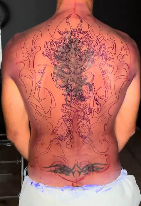 Pose du stencil du samouraï sur le dos avant tatouage